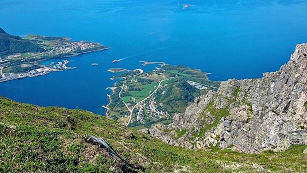 A coastal landscape with rugged cliffs and a bay with small islands. - 4 Person Holiday Home in Brattvag (Ålesund)