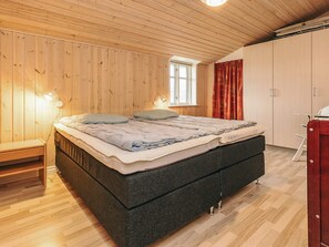 A bedroom with a bed, bedside lamps, a window, and a wardrobe. - 6 Person Holiday Home in Lokken (Lokken)
