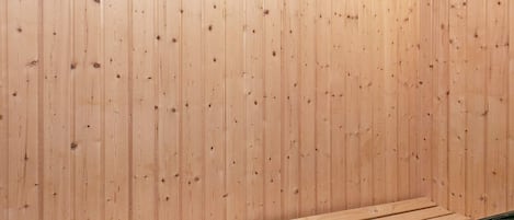 A sauna with wooden walls and a bench.