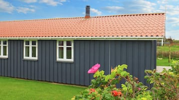 A single-story building with a red-tiled roof and a grey exterior wall.