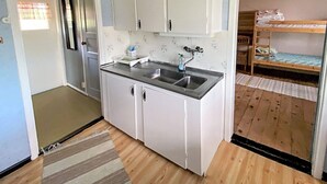 A compact kitchenette with two sinks, white cabinets, and a striped rug. - 6 Person Holiday Home in Lottorp (Löttorp)
