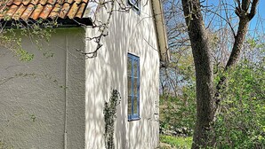 A white building with a tiled roof, a window, and a tree in the background. - 6 Person Holiday Home in Lottorp (Löttorp)