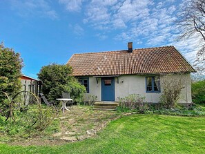 A single-story house with a tiled roof, a front door, and a small front yard with a lawn and some plants. - 6 Person Holiday Home in Lottorp (Löttorp)
