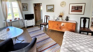 A cozy room with a round table, a sofa, a wooden dresser, and a television. - 6 Person Holiday Home in Lottorp (Löttorp)