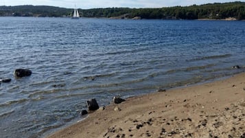 Una spiaggia sabbiosa con impronte che si inoltrano nell'acqua.
