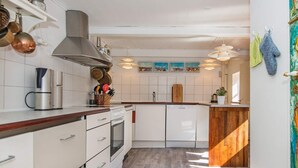 Eine moderne Küche mit weißen Schränken, Edelstahlgeräten und einer Holz Arbeitsplatte.