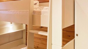 Un lit superposé avec un plancher en bois et une porte.