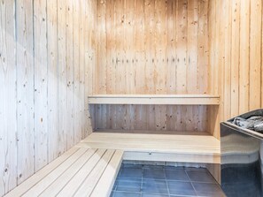 A sauna with wooden walls and a bench.