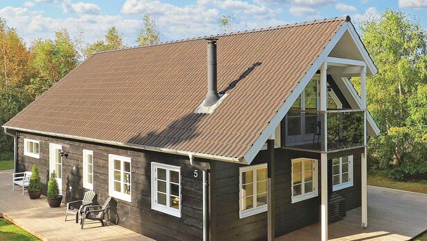 A wooden cabin with a sloped roof, a deck, and a small porch area. - Holiday Home in LÃ¦sÃ¸ (Læsø)