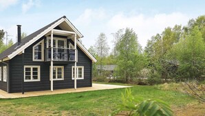 A two-story house with a balcony, a wooden deck, and a grassy yard. - Holiday Home in LÃ¦sÃ¸ (Læsø)