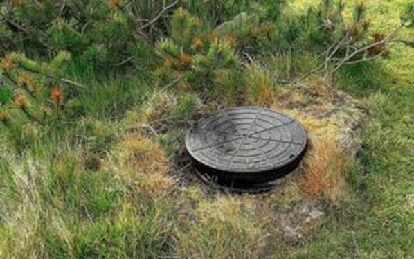 A manhole cover in a grassy area. - Holiday Home in RingkÃ¸bing (Ringkobing)