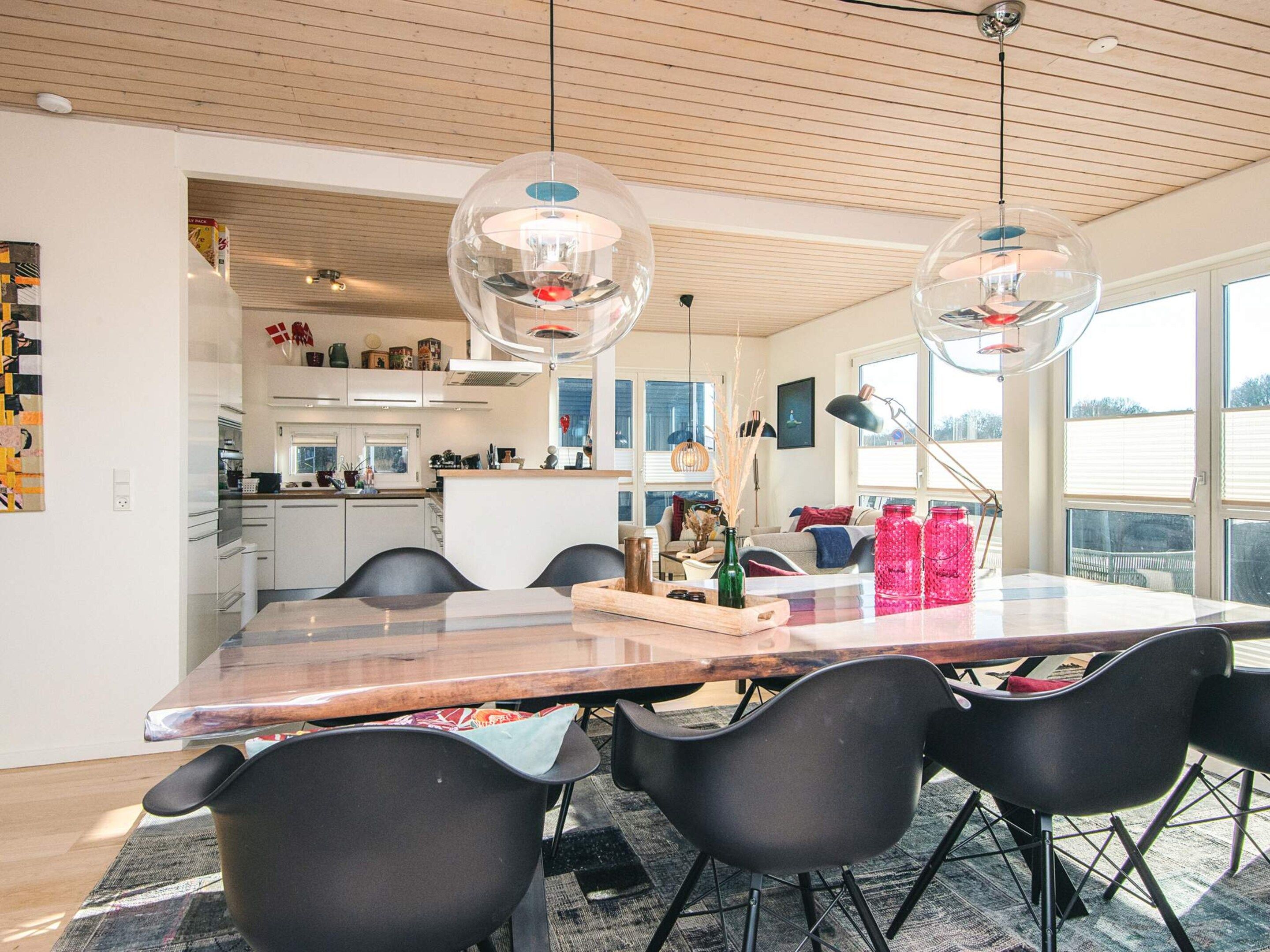 Una cucina moderna con zona pranzo, ampie finestre e vista sull'esterno.