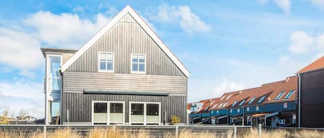 A modern two-story house with a prominent gable roof and large windows.