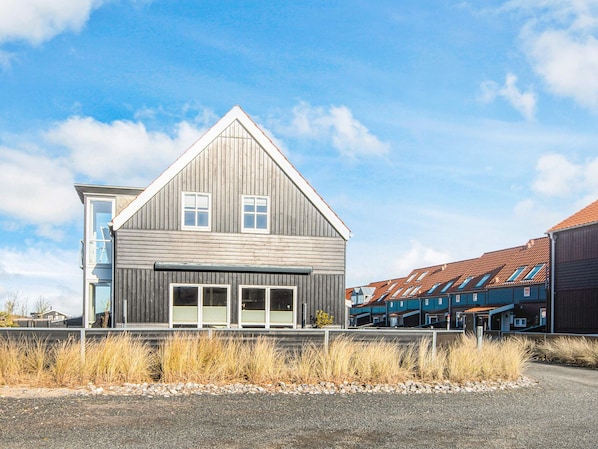 A modern two-story house with a prominent gable roof and large windows.
