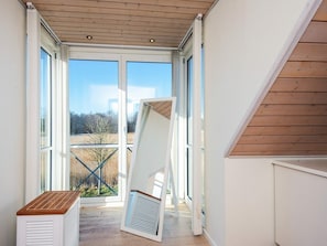 A room with a sloped ceiling, large windows, and a view of a landscape.