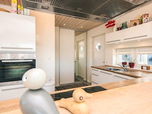 Une cuisine moderne équipée d’un four encastré, d’un évier et d’une fenêtre donnant sur un beau paysage.