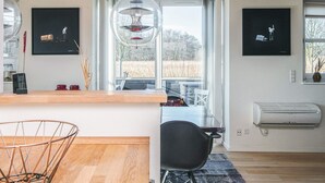 Una cocina moderna con encimera de madera, una silla negra y un ventanal con vistas al exterior.
