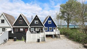 Três casas com cores diferentes e um caminho de acesso de cascalho.