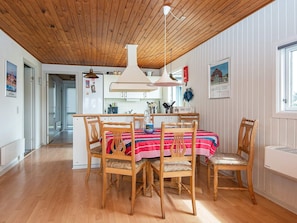 Relax in this open-plan living space with a high ceiling, dining area, and comfortable seating for four.