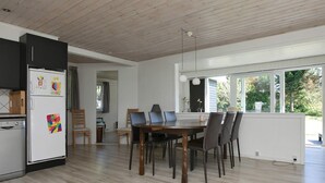 A modern kitchen with a dining area, wooden flooring, and large windows. - Holiday Home in VÃ¦ggerlÃ¸se (Vaeggerlose)
