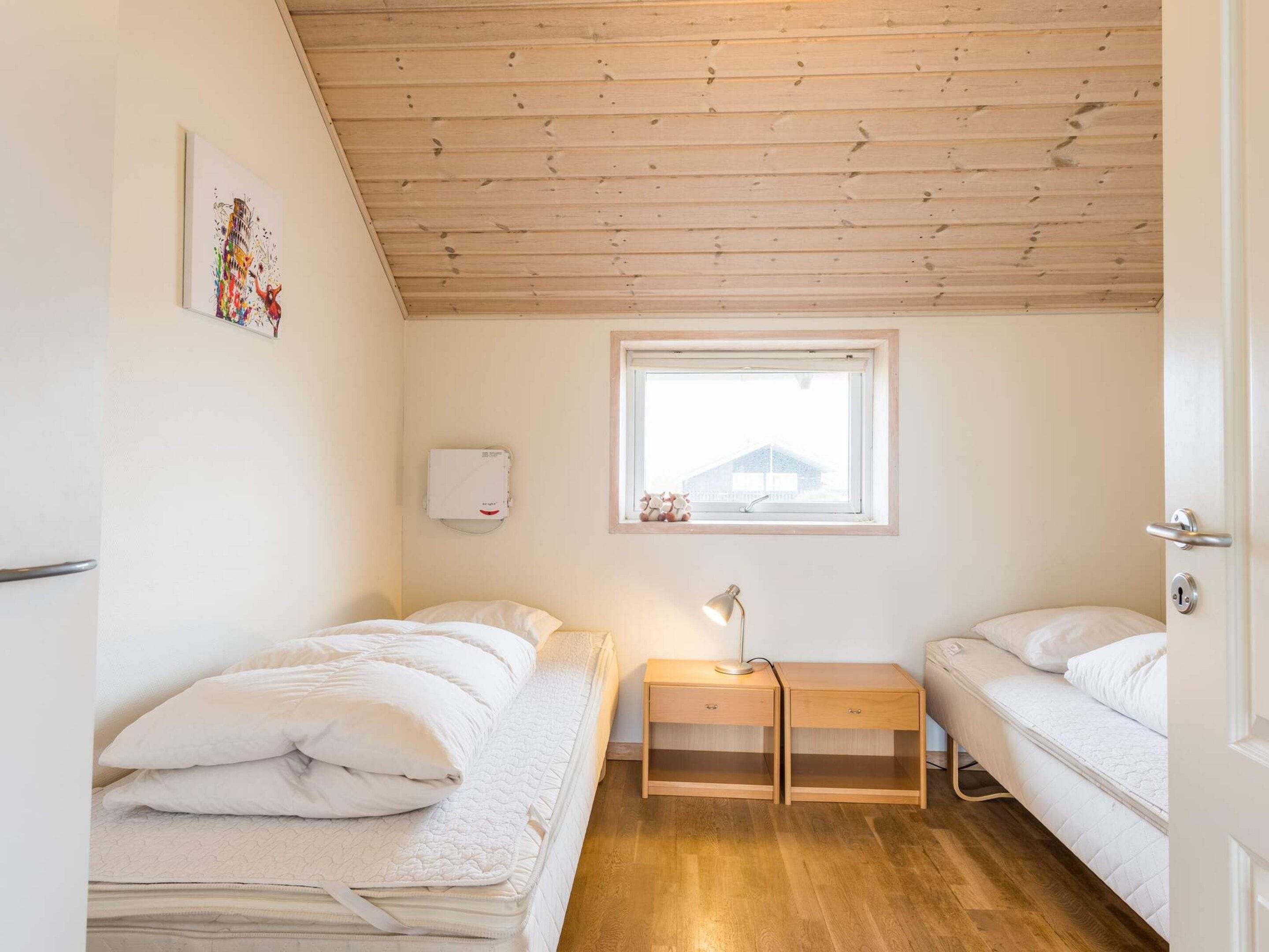 Allotjament petit d'una sola habitació amb dues lliteres, una finestra, una tauleta de nit i un calefactor fixat a la paret.