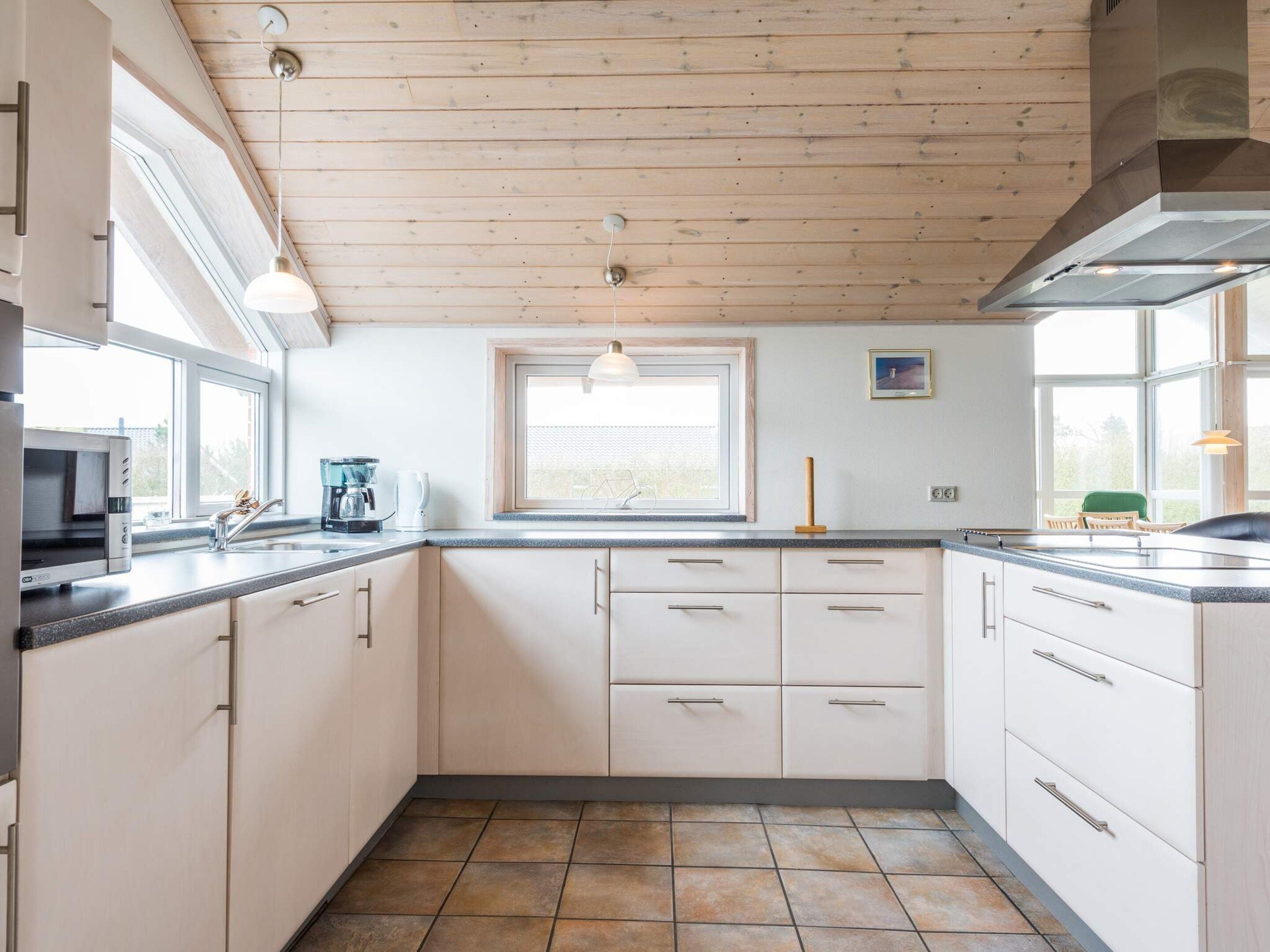 Una cocina con ventana, estufa y pileta.