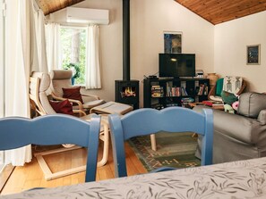 A cozy living room with a fireplace, a television, and a bookshelf. - 6 Person Holiday Home in Vaeggerlose (Vaeggerlose)