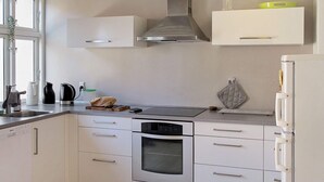 A modern kitchen with white cabinets, a stainless steel oven, and a built-in microwave.