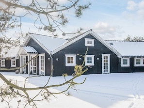 A black wooden house with white trim and a snow-covered landscape. - 5 Star Holiday Home in Blavand (Blavand)