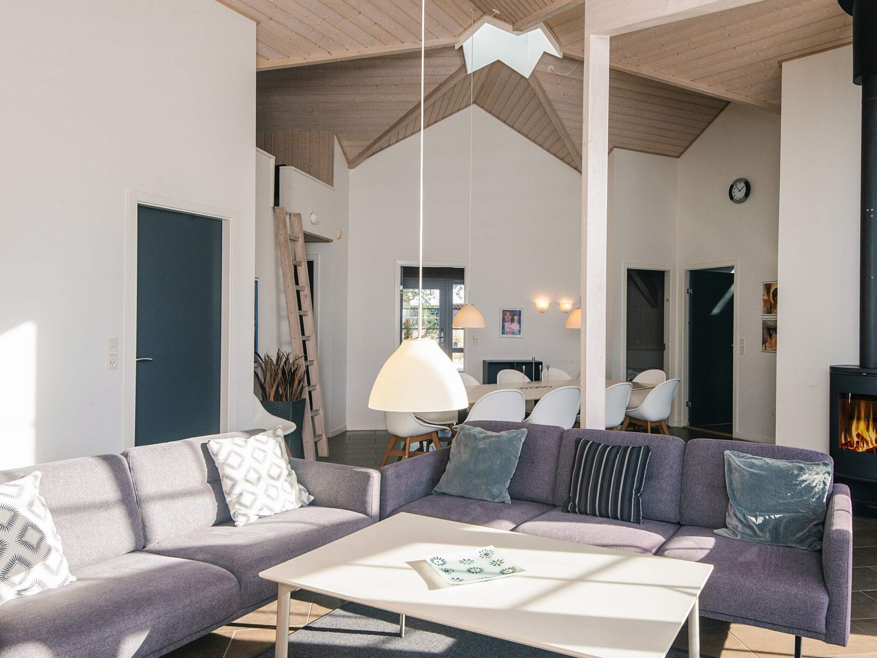 A modern living room with a sofa, coffee table, and a fireplace.