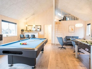A pool table, a foosball table, and a sofa in a room with wooden walls and a high ceiling. - 5 Star Holiday Home in Norre Nebel (Norre Nebel)