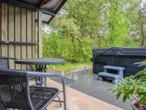 An outdoor patio with a table and chairs, a barbecue grill, and a covered seating area. - 4 Star Holiday Home in Norre Nebel (Norre Nebel)