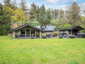 A modern house with a patio area, a hot tub, and a covered outdoor seating area. - 4 Star Holiday Home in Norre Nebel (Norre Nebel)