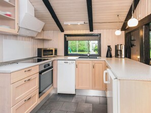 A modern kitchen with a microwave, dishwasher, and coffee maker. - 4 Star Holiday Home in Norre Nebel (Norre Nebel)
