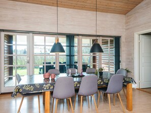 Un comedor con una mesa dispuesta para cuatro personas, rodeada de sillas con patas de madera.