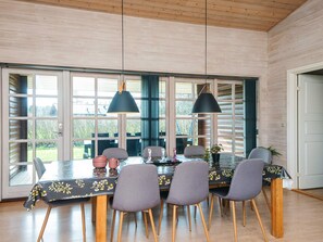 A dining area with a table set for four, surrounded by chairs with wooden legs.