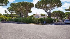 A residential street with houses, a clear sky, and a white car parked on the right. - Lovely Villa in Vilamoura With Private Pool (Loulé)