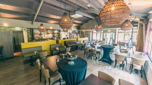 A restaurant with high ceilings, hanging wicker chandeliers, and a bar area. - Modern Chalet With Dishwasher, Near Utrecht (Maarn)