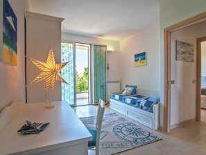 A modern bedroom with a bed, a nightstand, a star-shaped lamp, and a view of the outdoors.