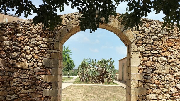 Une structure en pierre en forme d’arche, avec un sentier qui la traverse.