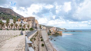 A coastal town with historic buildings, a stone pathway, and a view of the sea. - Vue Merveilleuse Apartment (Castellammare del Golfo)