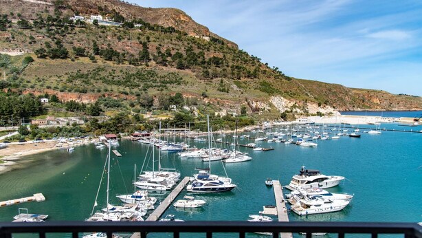 A marina with boats docked, a dock, and a hilly landscape in the background. - Vue Merveilleuse Apartment (Castellammare del Golfo)