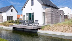 A modern house with a flat roof, large windows, and a balcony with outdoor furniture. - Modern Holiday Home, Near the Sea (Bredene)