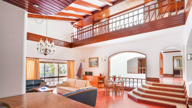 A spacious living area with a wooden staircase, a dining table, and a sofa. - Villa in Vilamoura With Pool Near Beach (Loulé)