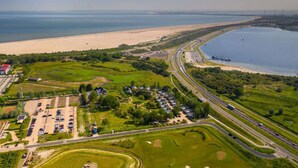 Vista aérea de una zona costera con una autopista, una playa y un puerto deportivo.