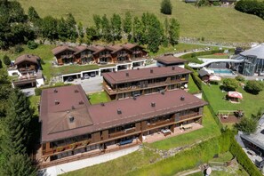 A multi-story lodge with a central courtyard, outdoor seating, and a swimming pool.