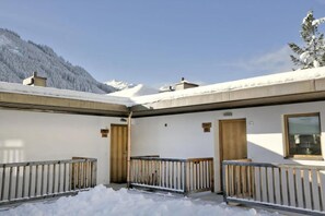 A snow-covered outdoor area with a building, wooden railings, and a mountain backdrop. - Inviting Chalet in Wald im Pinzgau (Wald im Pinzgau)