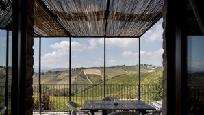 A covered outdoor seating area with a table and chairs, overlooking a hilly landscape. - Serene Escape, Ascoli Piceno (Ripatransone)