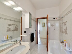 Ein Badezimmer mit zwei Waschbecken, einer Badewanne und einer Dusche.