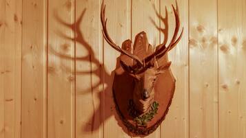 A wooden wall with a mounted deer head sculpture.